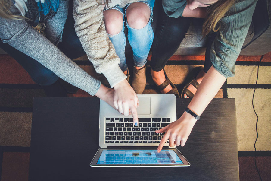Persone indicano lo schermo di un pc