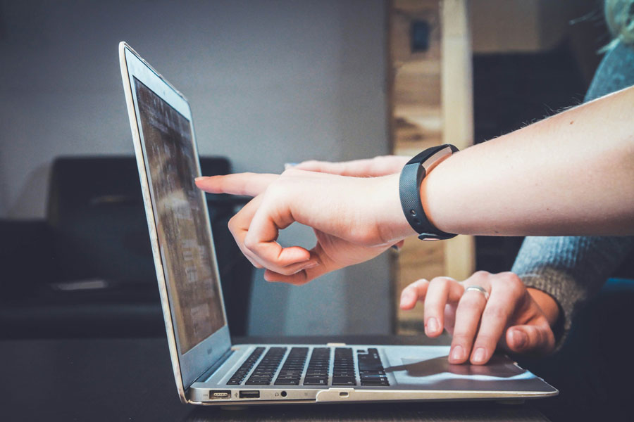 persona indica un punto dello schermo del computer al compagn